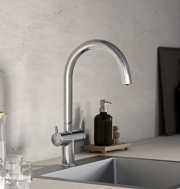 Chromowana bateria kuchenna Ferro Filtrata z wysoką wylewką, zamontowana nad zlewozmywakiem, obok ciemnego dozownika mydła i szczotki do naczyń.